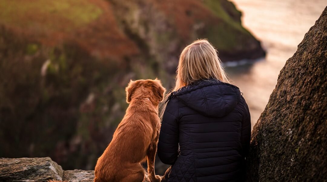 Perro disfrutando del aire libre junto a su cuidadora durante una escapada